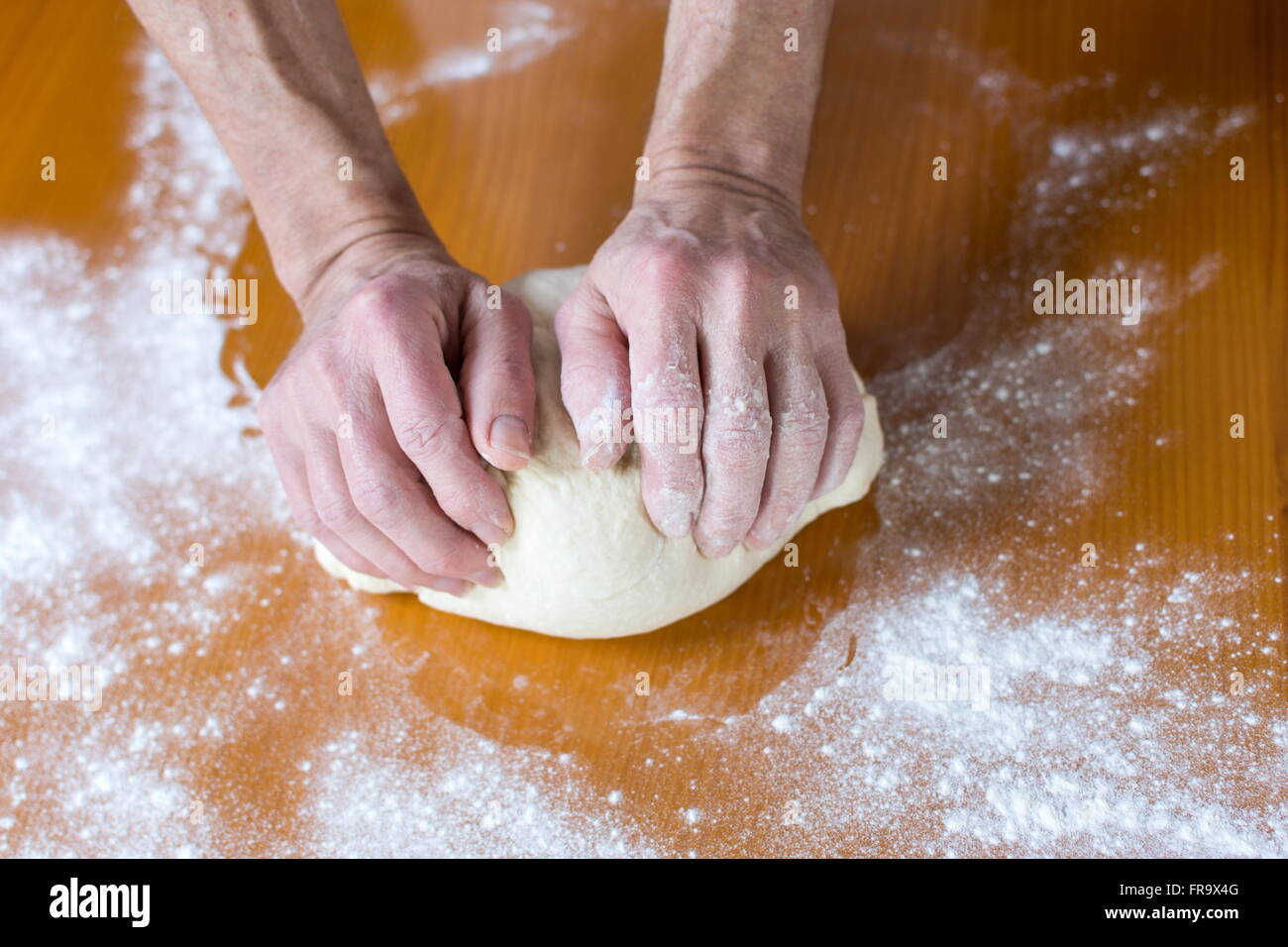 Hände eines männlichen Bäckers, die Herstellung von Brot auf dem Tisch Stockfoto