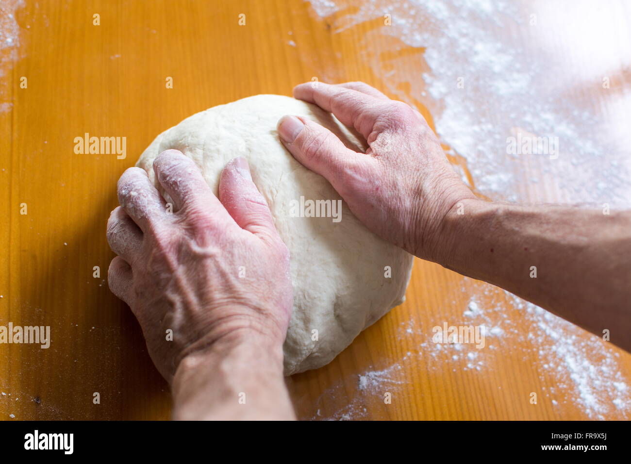 Hände eines männlichen Bäckers, die Herstellung von Brot auf dem Tisch Stockfoto