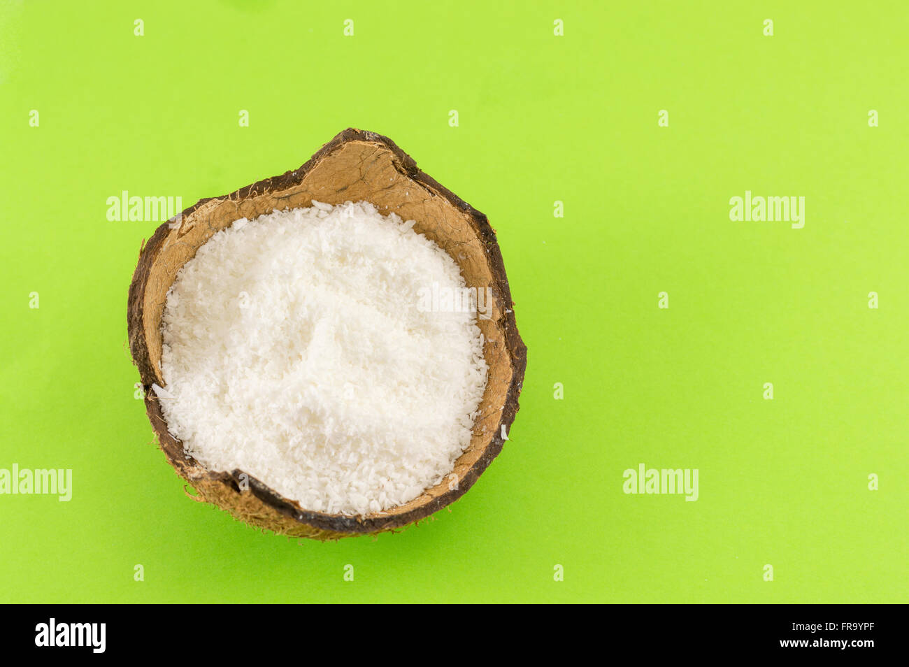 Kokos Pulver in Kokosnussschalen auf grünem Hintergrund Stockfoto