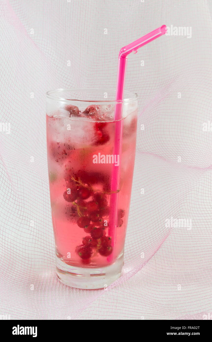 Früchte-Beeren-Saft mit Eiswürfeln weiche rosa Hintergrund Stockfoto