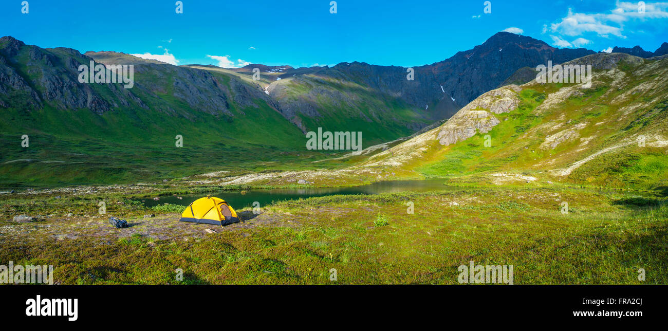 Ein Mann auf seinem Campingplatz am hängenden Tal in South Fork in der Nähe von Eagle River an einem Sommertag in South Central Alaska. Stockfoto