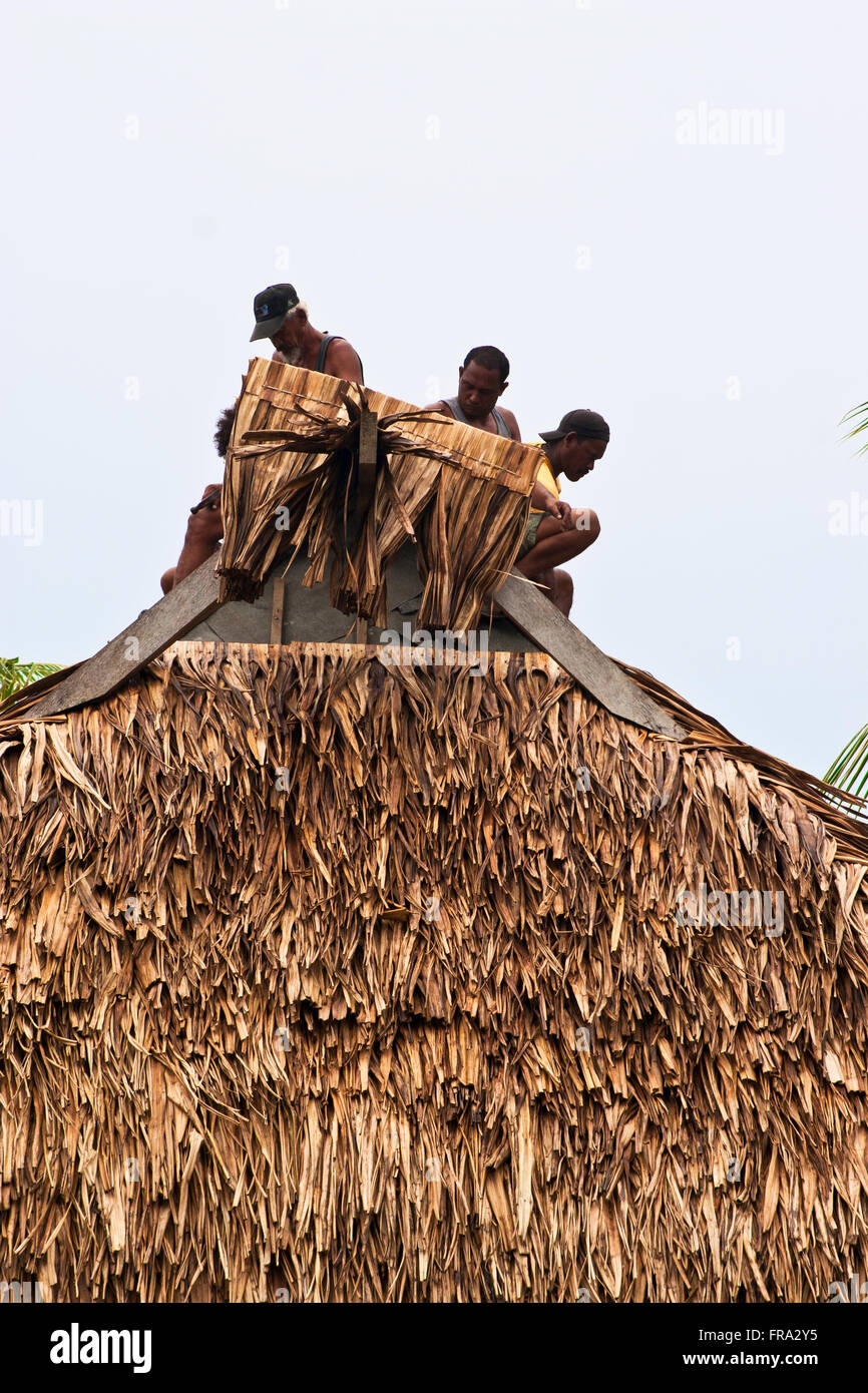 Insel Moorea, Französisch-Polynesien, drei Männer, die ein Bungalow Dach Palm Stroh zuweisen. Stockfoto