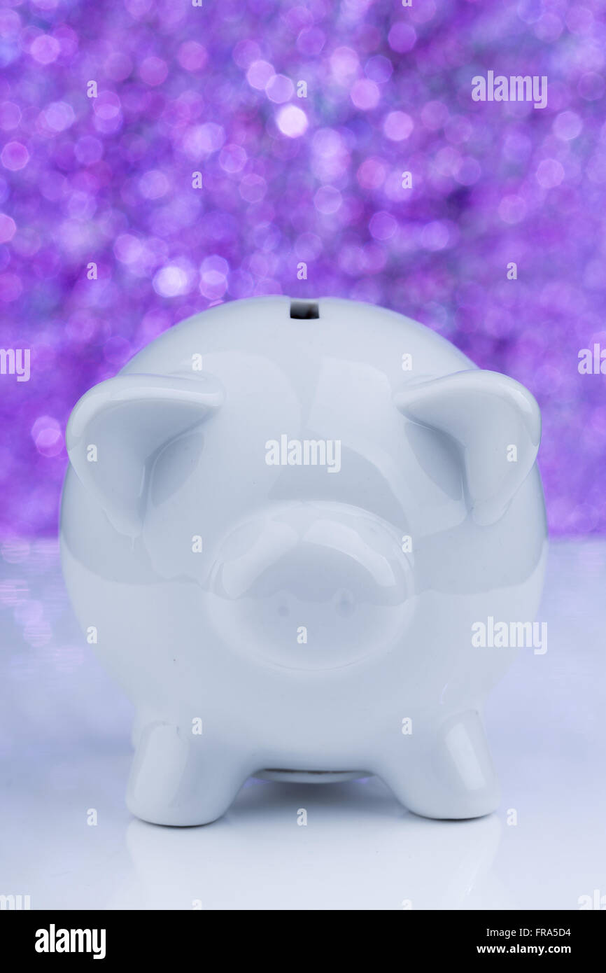 Weiße Sparschwein auf lila Hintergrund Stockfoto