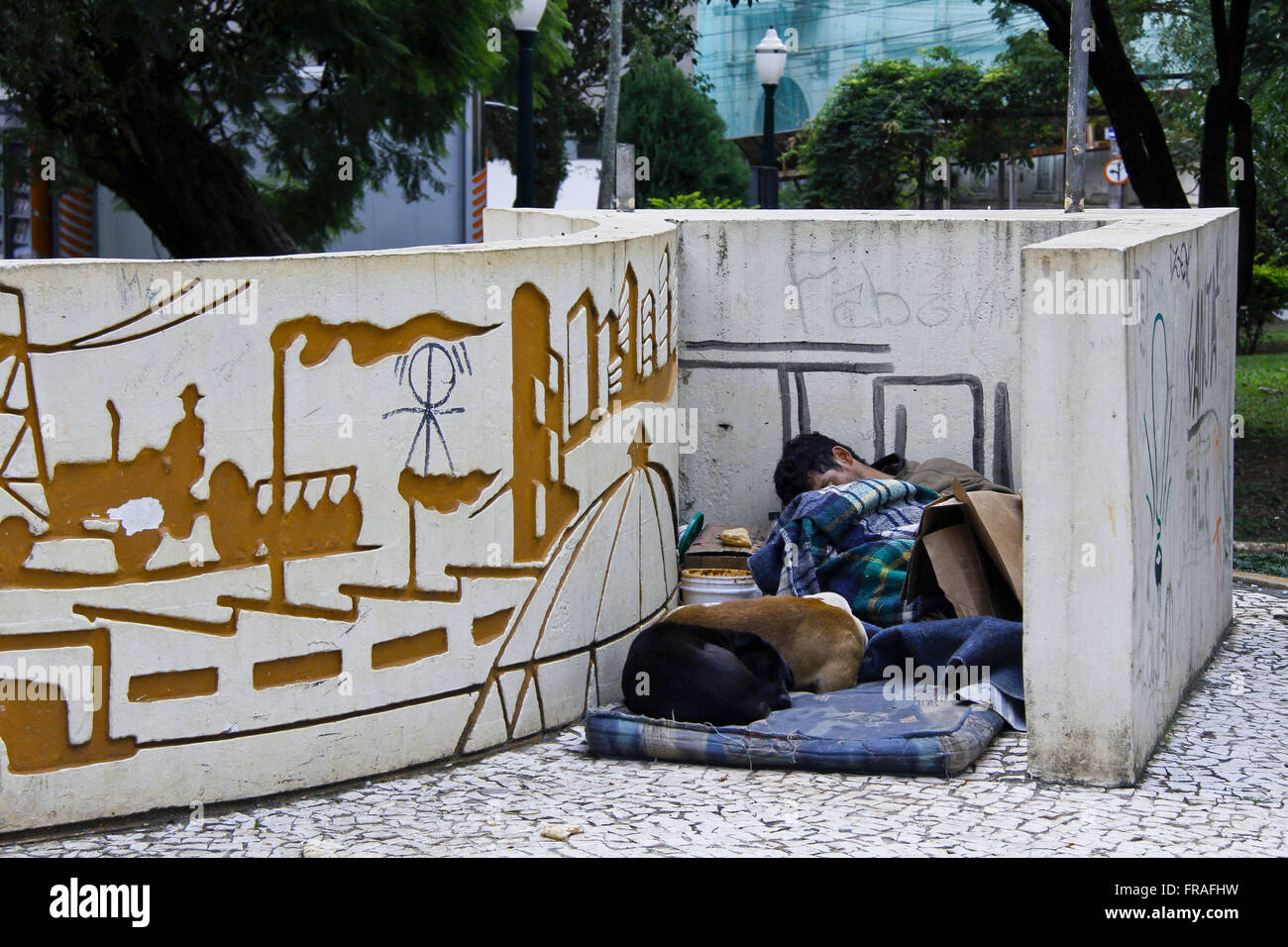 Obdachlose schlafen mit ihren Hunden am Denkmal in der Innenstadt Stockfoto