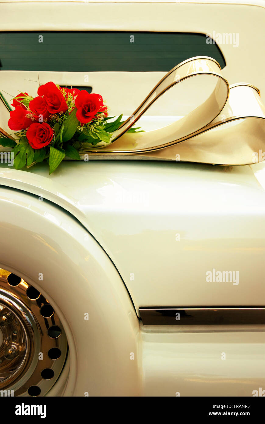 Limousine-Rückseite mit Blumen verzierten. Weiße Hochzeit Retro-Auto Nahaufnahme. Gelb getönt. Stockfoto