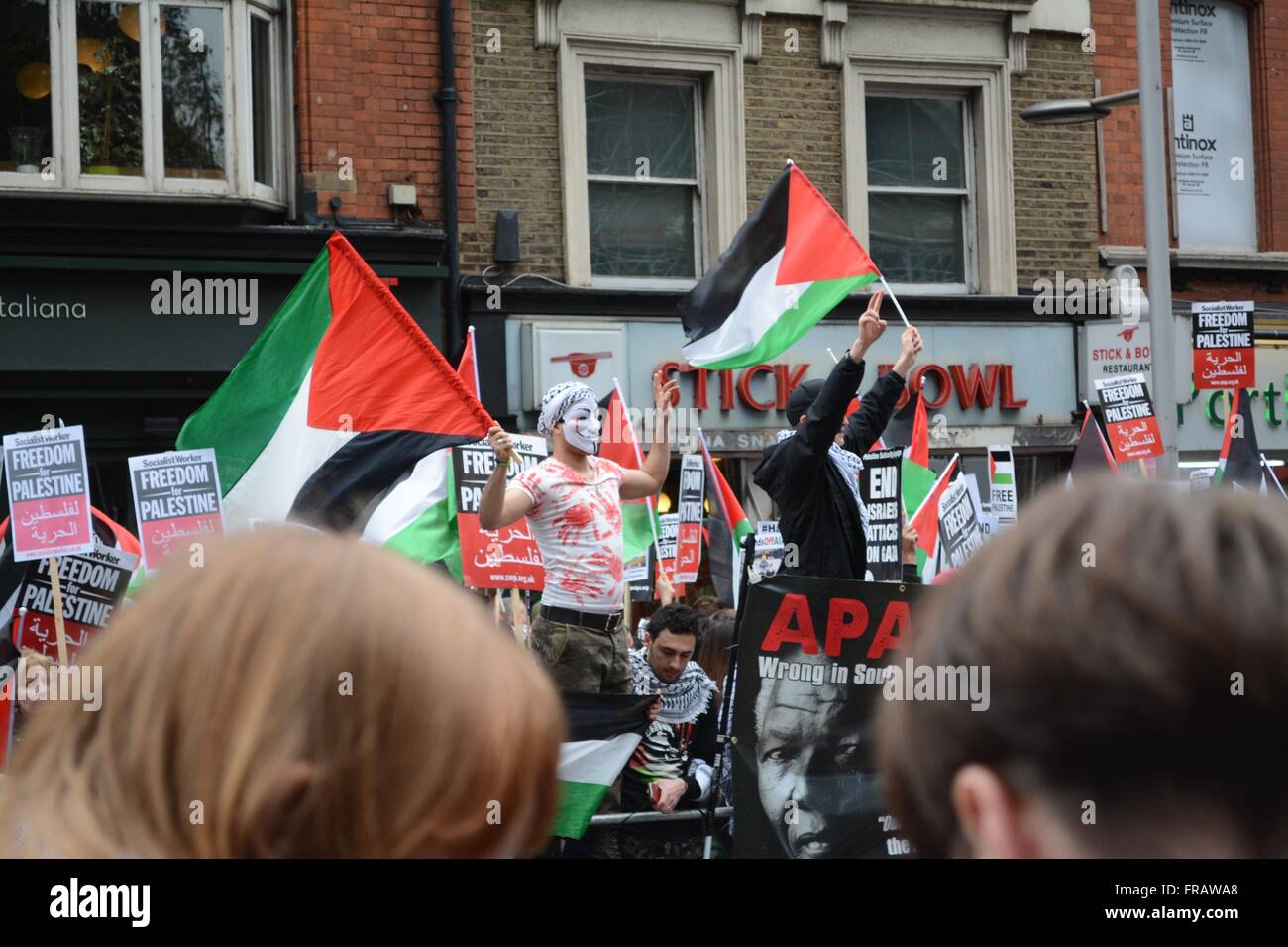 17. Oktober 2015. London, England. Demonstrant in einer Maske, gleichbedeutend mit der Anonymous-Bewegung, winkt eine Flagge vor der israelischen Botschaft. © Marc Ward/Alamy Stockfoto