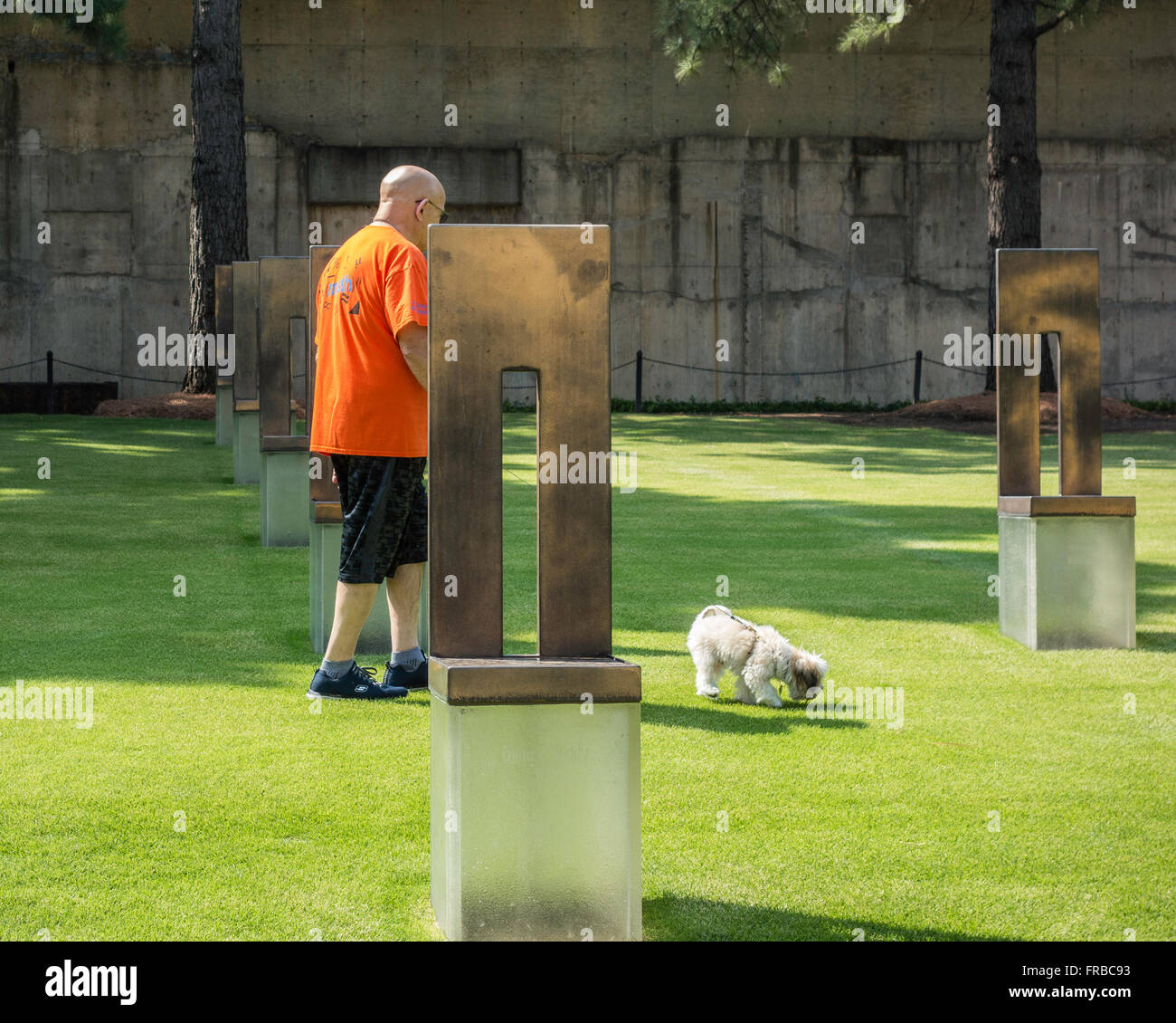 Ein senior kaukasischen Mann und sein Hund Spaziergänge durch die Stühle, die zu Ehren der Opfer von der Oklahoma Citybombardierung. Oklahoma, USA. Stockfoto