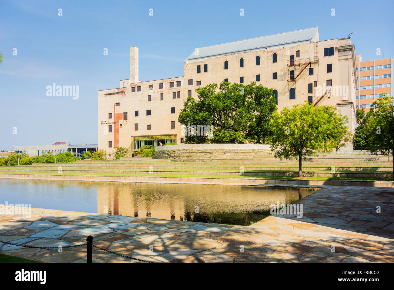 Die Oklahoma City Bombing Memorial Museum. Die hinterbliebenenversorgung Baum vor dem Gebäude, Reflexion pool im Vordergrund. Oklahoma City, Oklahoma, USA. Stockfoto