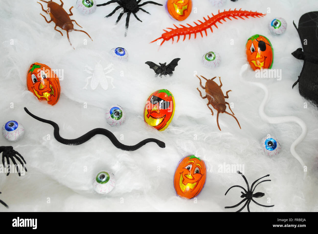 Verschiedene Halloween Süßigkeiten und Spielsachen auf einem Gurtband-Hintergrund Stockfoto