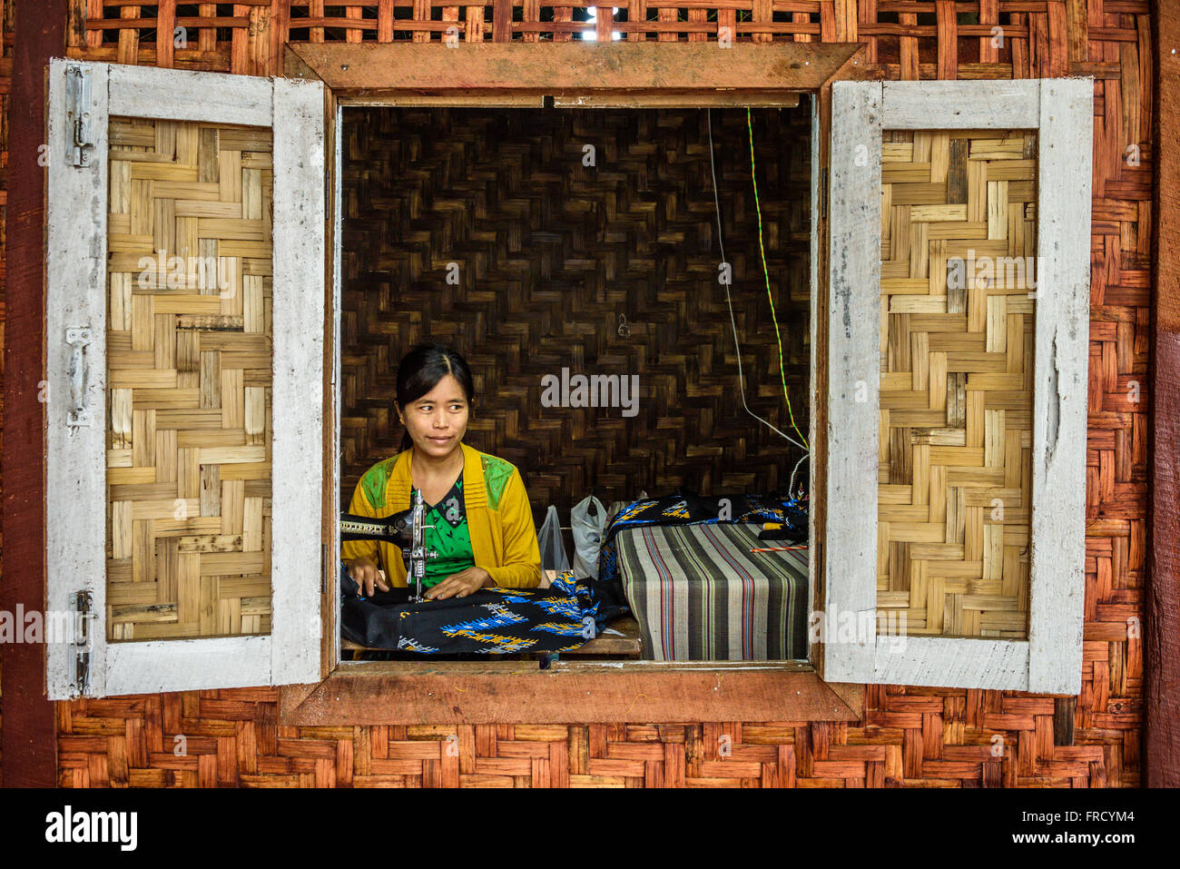 Junge asiatische Frau arbeitet an eine alte Nähmaschine Stockfoto