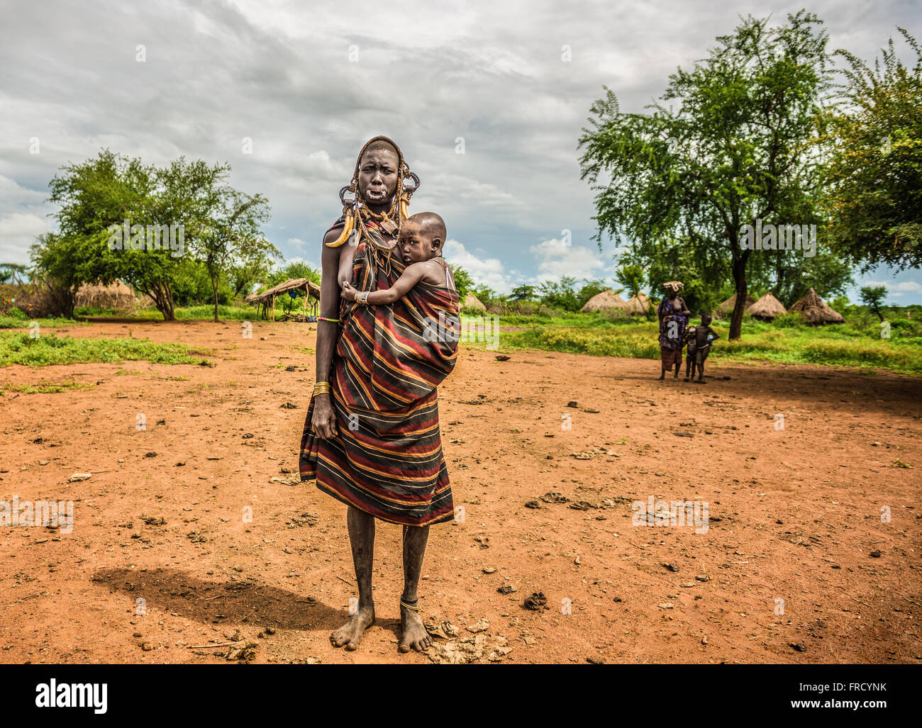 Frau aus dem afrikanischen Stamm Mursi mit ihrem baby Stockfoto