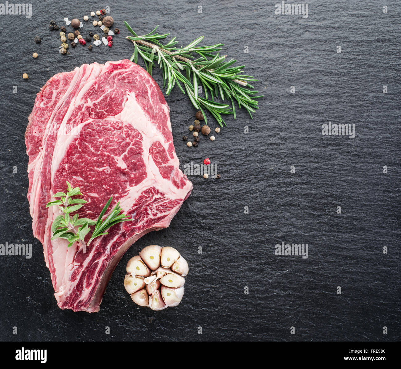 Rib-Eye Steak mit Gewürzen auf dem schwarzen Hintergrund. Stockfoto