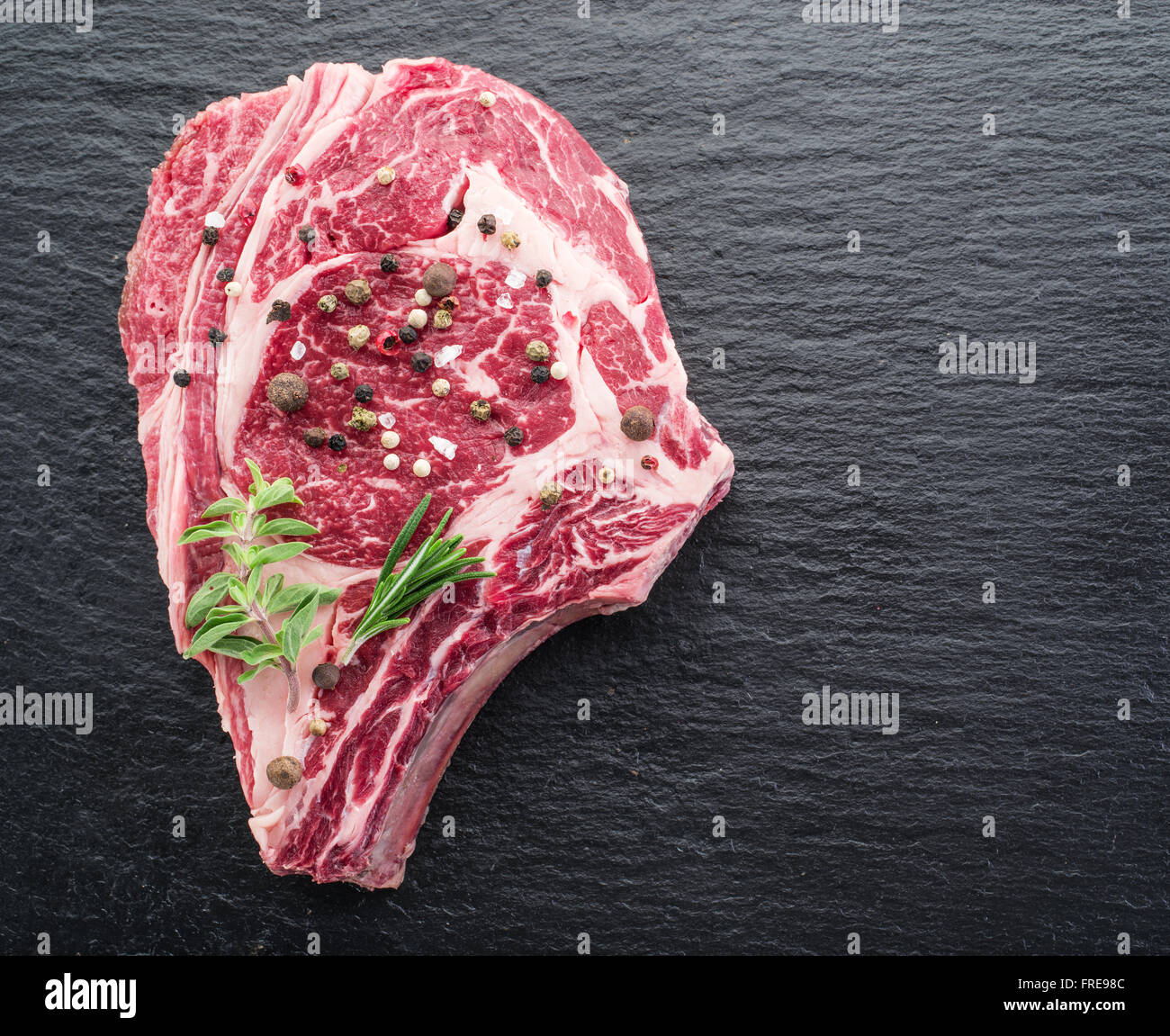 Rib-Eye Steak mit Gewürzen auf dem schwarzen Hintergrund. Stockfoto