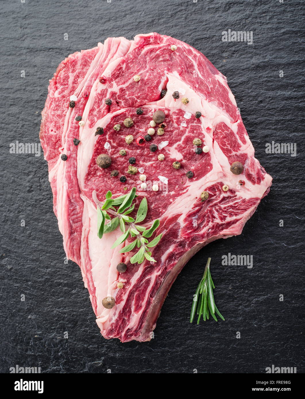Rib-Eye Steak mit Gewürzen auf dem schwarzen Hintergrund. Stockfoto