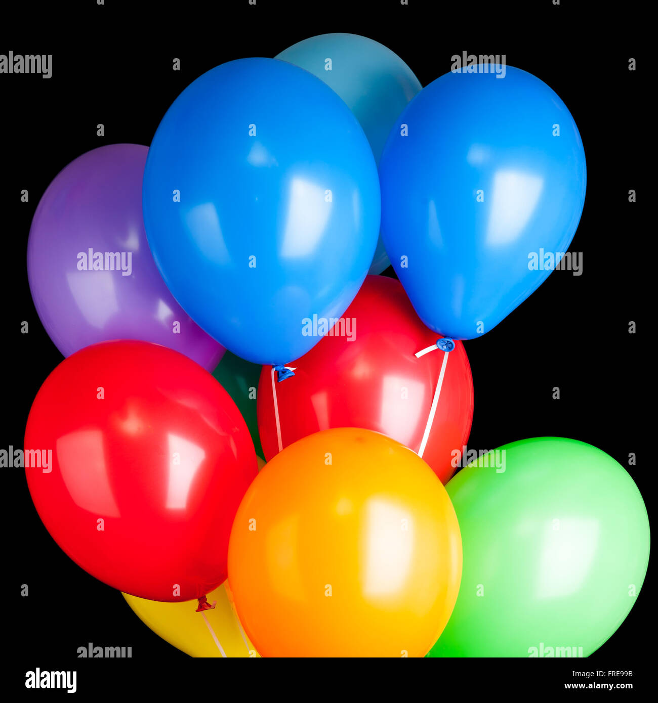 Gruppe von bunten Luftballons auf Bändern auf schwarzem Hintergrund isoliert Stockfoto