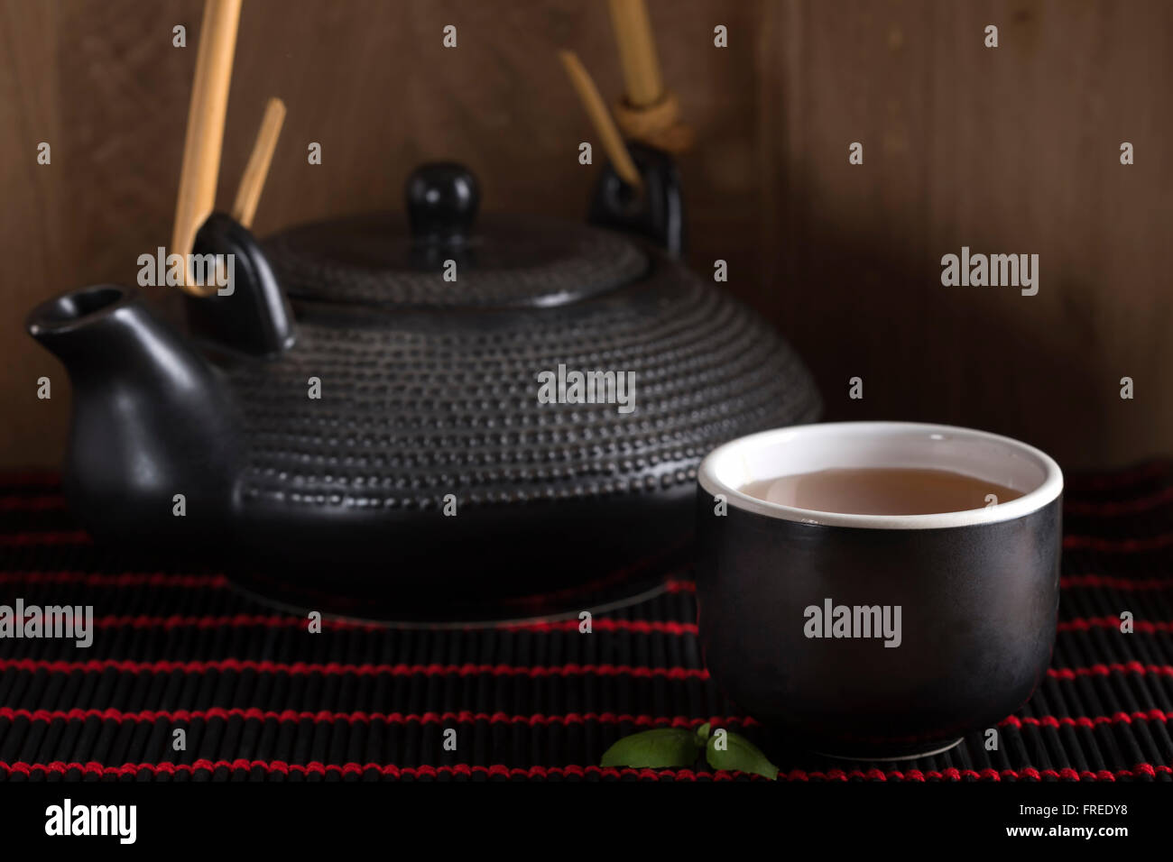 Bild der traditionellen östlichen Teekanne und Teetasse auf Bambus Teppich Stockfoto