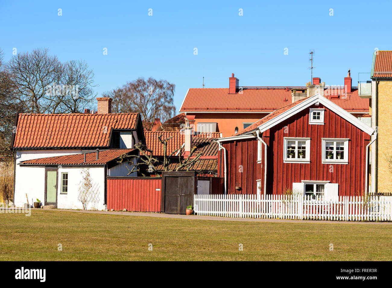 Kalmar, Schweden - 17. März 2016: Eine alte rote Holzhaus mitten in der Stadt mit modernen Gebäuden im Hintergrund. WHI Stockfoto