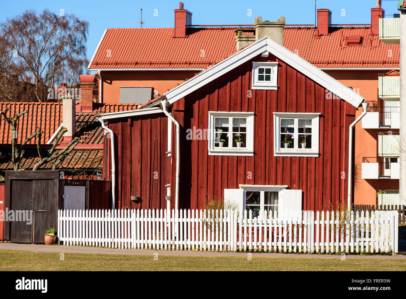 Kalmar, Schweden - 17. März 2016: Eine alte rote Holzhaus mitten in der Stadt mit modernen Gebäuden im Hintergrund. WHI Stockfoto