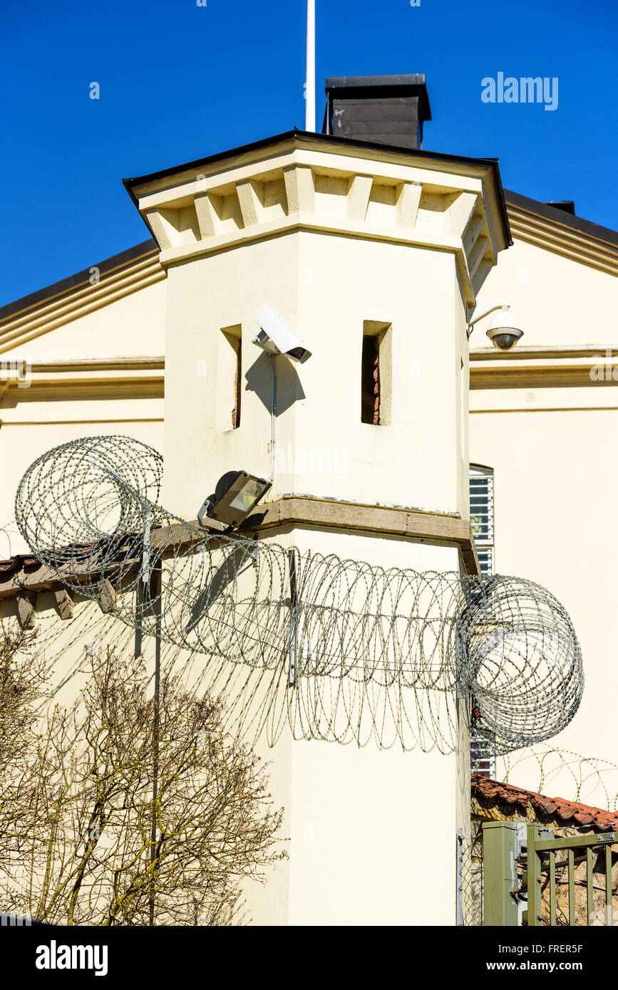 Ein kleines Gefängnis Wachturm mit Stacheldraht rundherum. Ferngesteuerte Kameras und Scheinwerfer an der Turmwand befestigt sind. Stockfoto