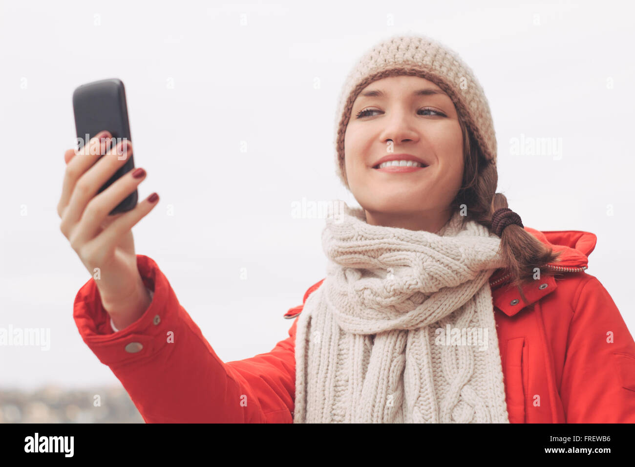 Junge Frau, mit mobilen nehmen Foto oder senden Nachricht im freien Stockfoto