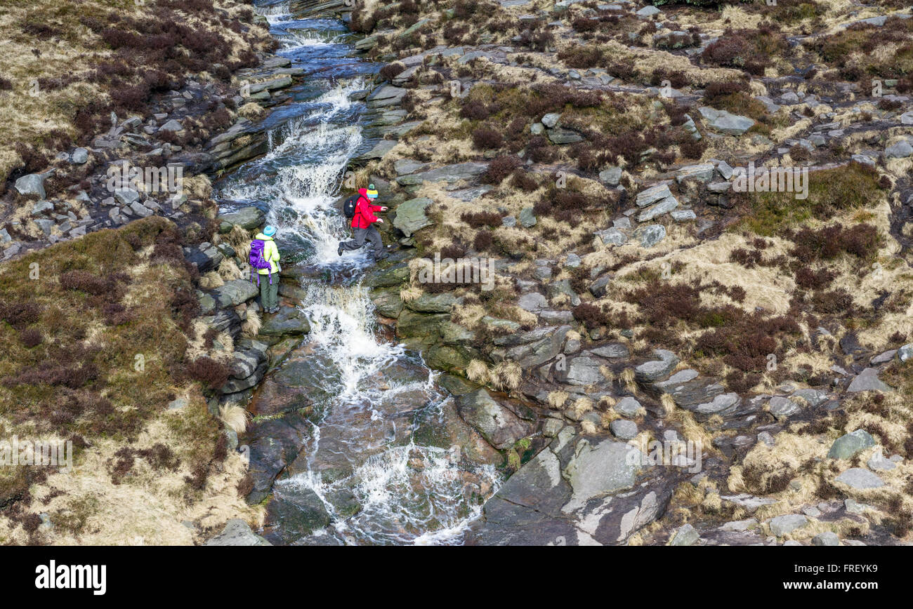 Wanderer durchqueren schleift Bach an Kinder Scout im Peak District in Derbyshire, England, Großbritannien Stockfoto