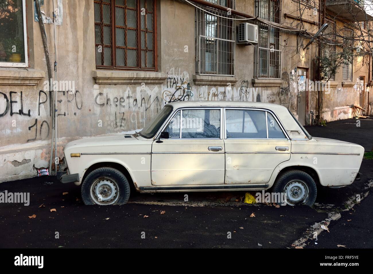 Faulen Arbeiter haben einen Parkplatz um einen Mietwagen in Baku, der Hauptstadt von Aserbaidschan wieder aufgetaucht. Eine amüsante Szene mit einer Insel von Asphalt Stockfoto