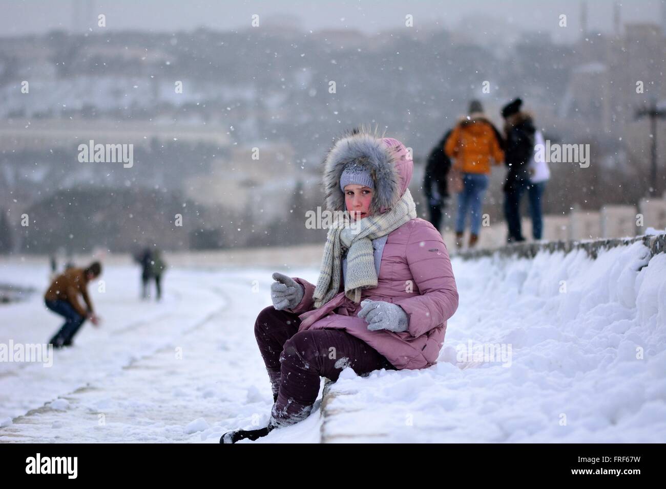 Junges Mädchen in ein rosa Fell gut gewickelt-Up auf Baku Bulvar im Schnee, in der Hauptstadt von Aserbaidschan. Stockfoto