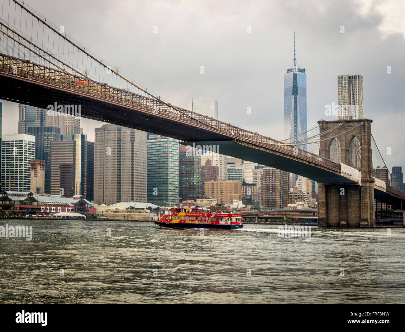 Touristenboot Sightseeing gehen unter Brooklyn Bridge Manhattan Skyline im Hintergrund, New York, USA. Stockfoto