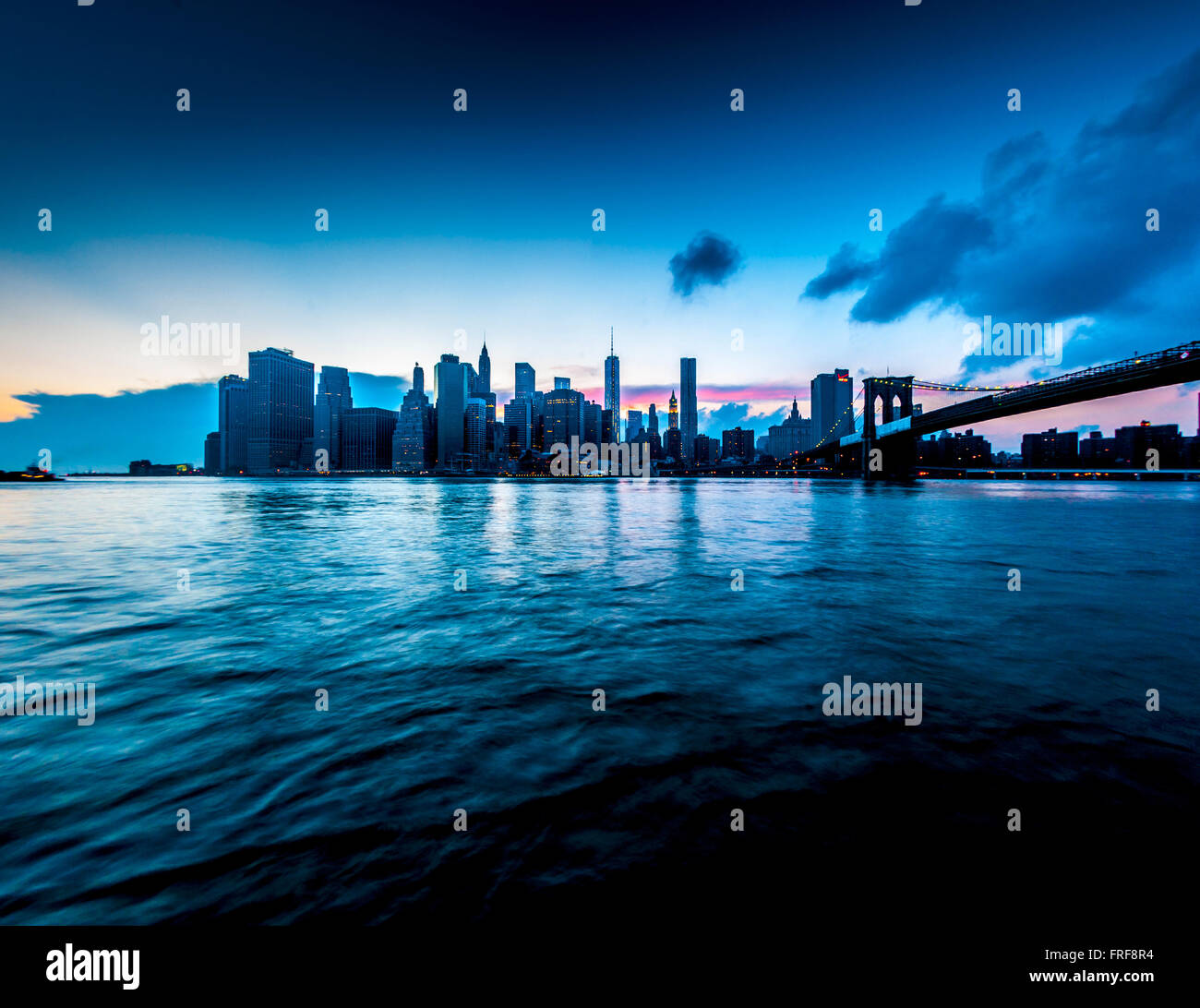 Skyline von Manhattan in der Dämmerung mit Brooklyn Bridge, New York, USA. Stockfoto