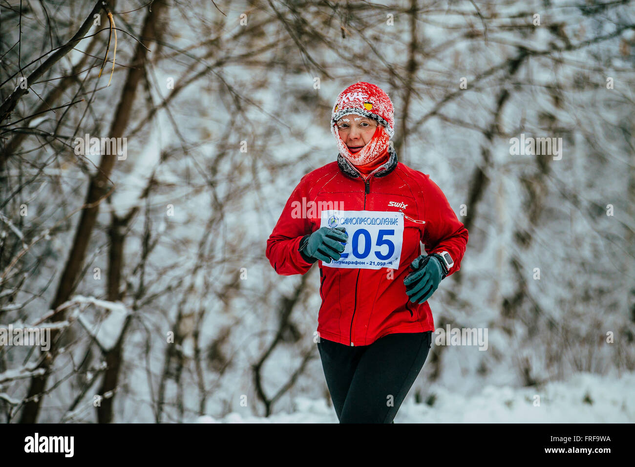 Frau mittleren Alters Athlet auf Winter schneebedeckte Allee im Park in Chelyabinsk Winter Marathon laufen Stockfoto