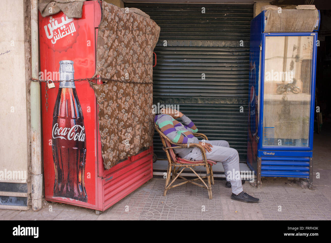 Ein ägyptischer Mann schläft ungeschickt in einem Stuhl neben