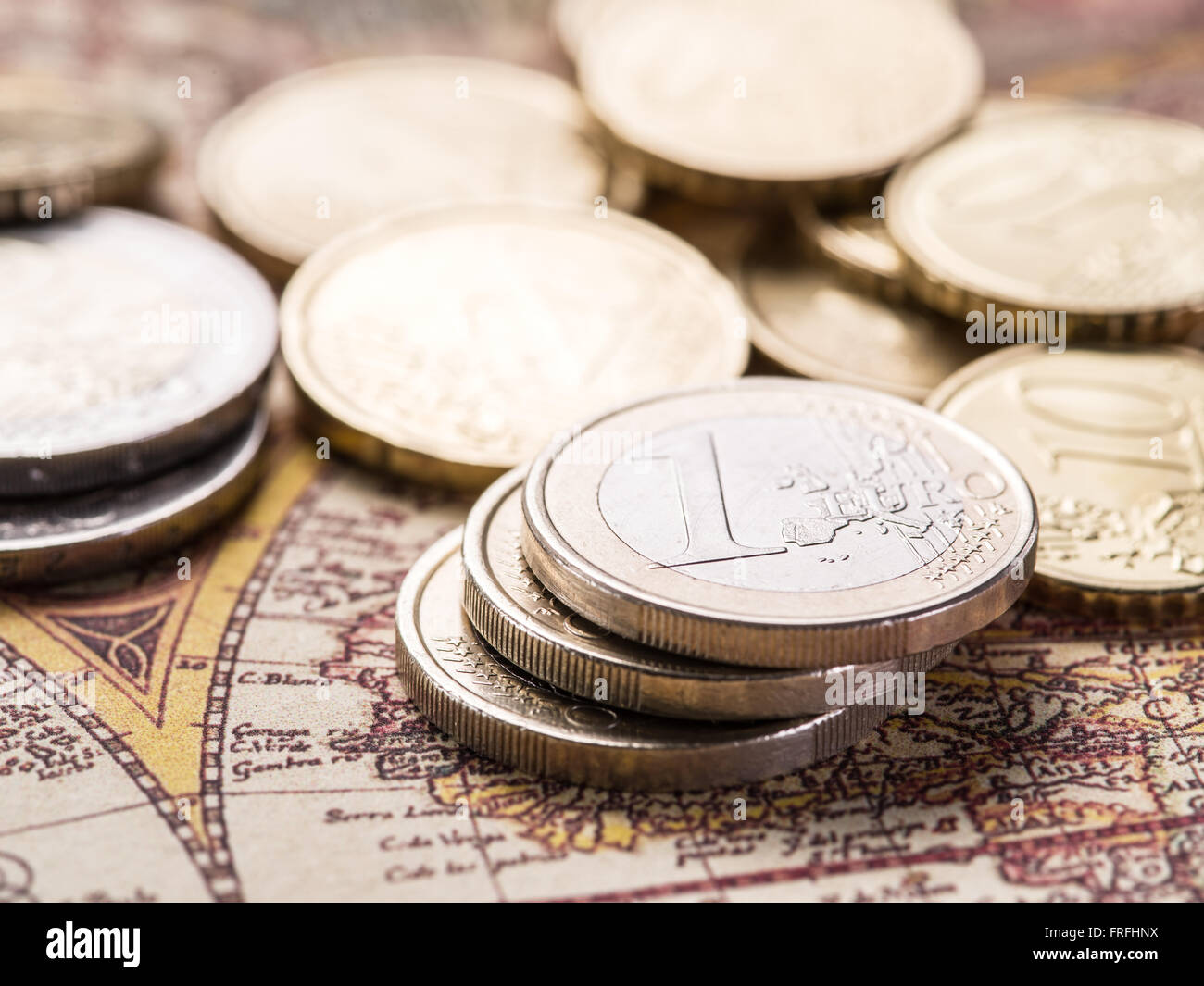 Euro-Münzen über die alte Weltkarte. Makro-Bild. Stockfoto