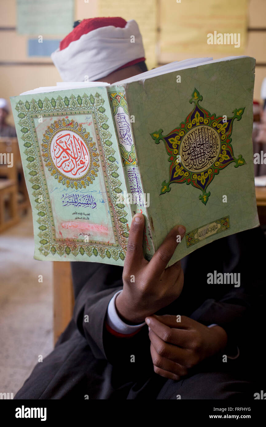 Ein Schuljunge Arabisch rezitiert Verse aus dem Koran in einem Klassenzimmer in der islamischen Koom al-Bourit Institut für Jungen aus dem Dorf Qum (Koom), auf der Westbank von Luxor, Nil Senke, Ägypten. Stockfoto