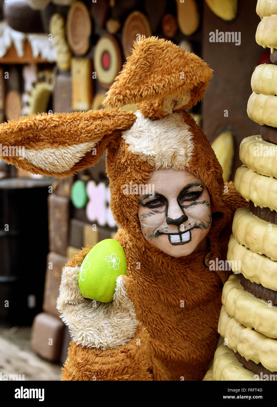 Potsdam, Deutschland. 22. März 2016. Eine Frau namens Dajana gekleidet wie der Osterhase schaut in ein Hexenhaus für ein Versteck für ein Easter Egg im Filmstudio Babelsberg in Potsdam, Deutschland, 22. März 2016. Das Filmstudio öffnet wieder am 23. März. Am Ostersonntag werden Sie traditionell von der übergroßen Osterhase begrüßt. Foto: BERND SETTNIK/Dpa/Alamy Live News Stockfoto