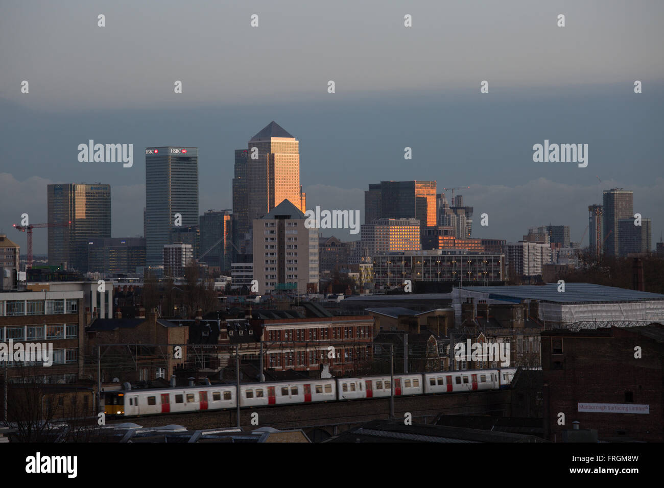 Canary Wharf Finanzviertel von Hackney in der Dämmerung, inkl. Kanada Platz 1 und HSBC Tower gesehen. Ein Zug vorbeifährt. Stockfoto