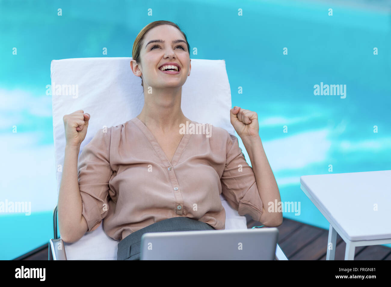Aufgeregt Frau mit Laptop in der Nähe von Pool Stockfoto