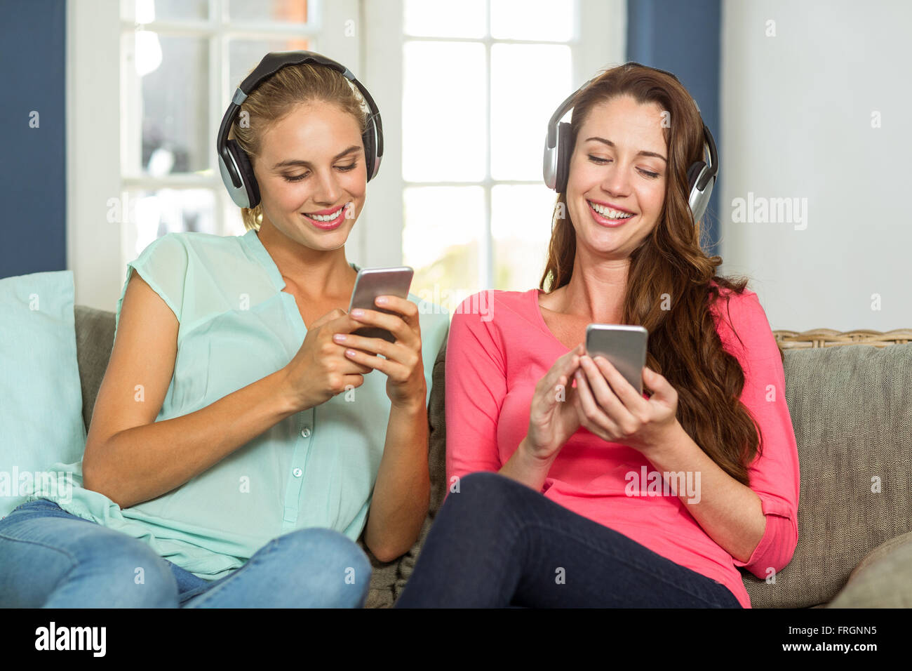 Freundinnen zu Hause Musik hören Stockfoto