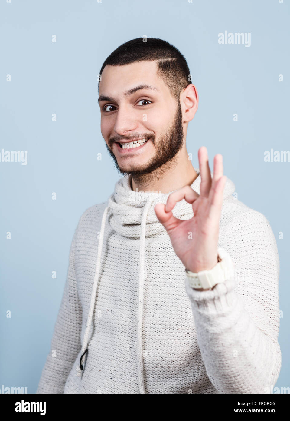 Schöner junger Mann zeigt OK Sign. Stockfoto