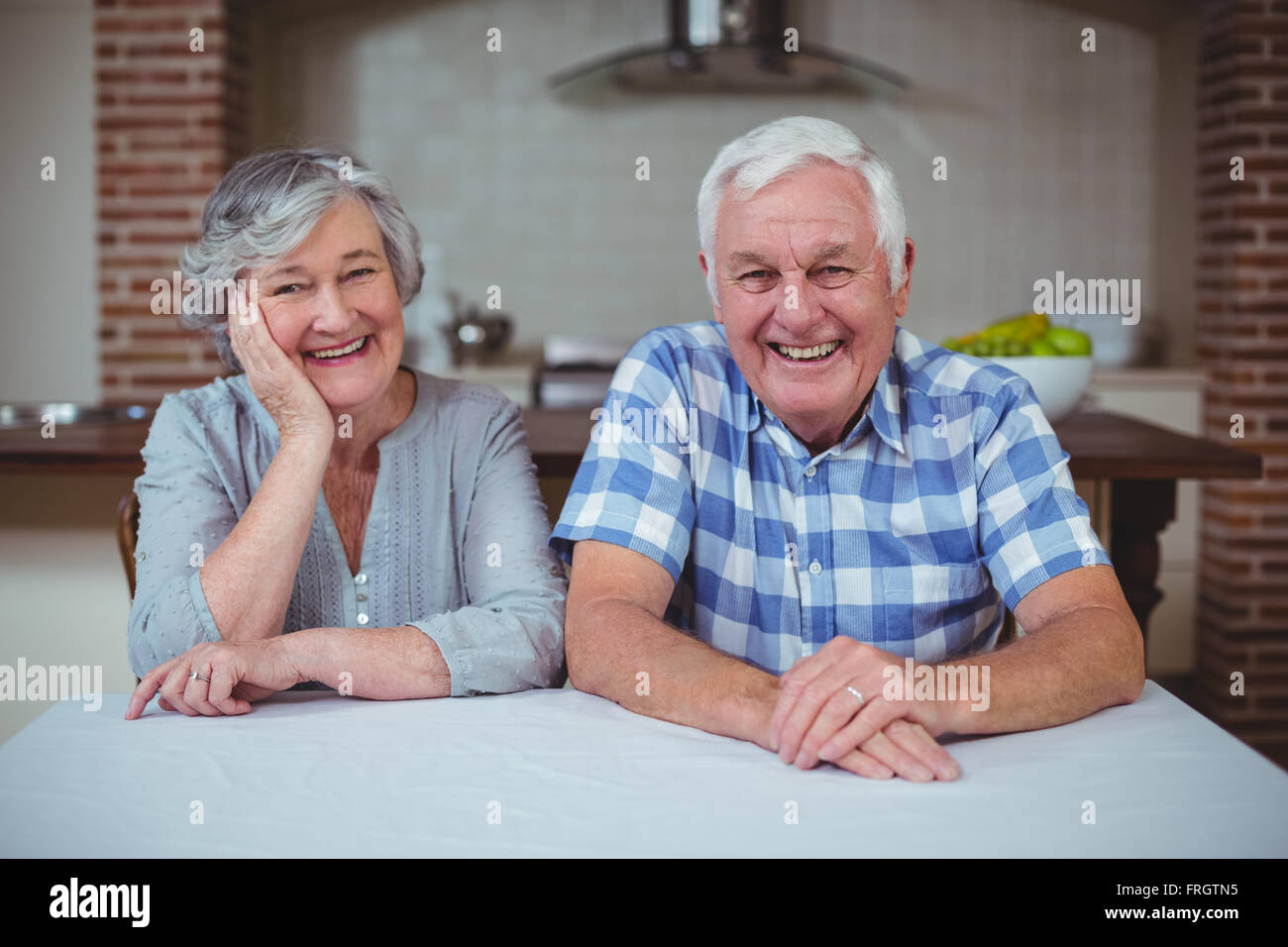 Porträt von senior paar sitzt in Küche Stockfoto