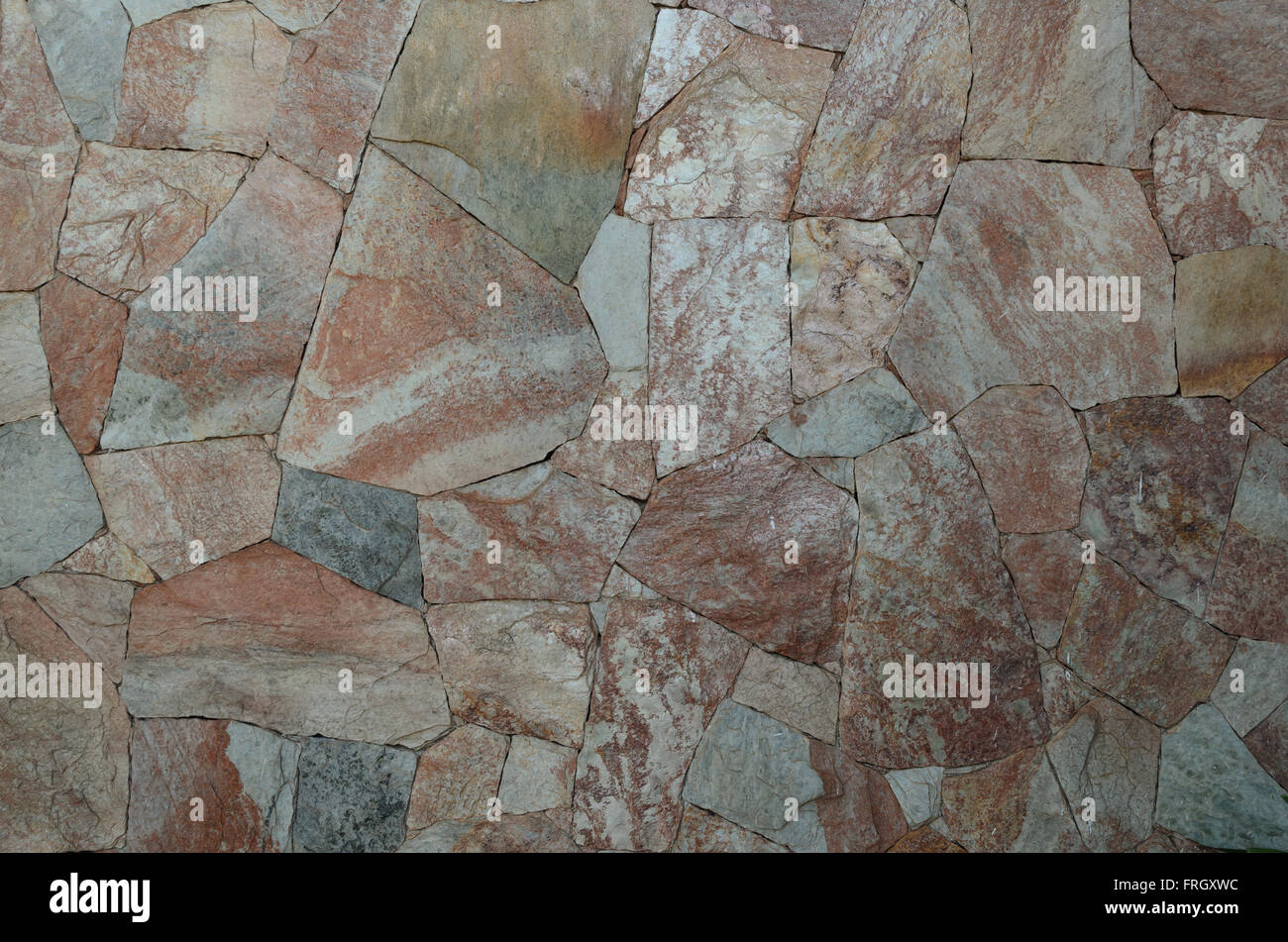 Foto der Hintergrund der farbigen Steinmauer Oberfläche Stockfoto