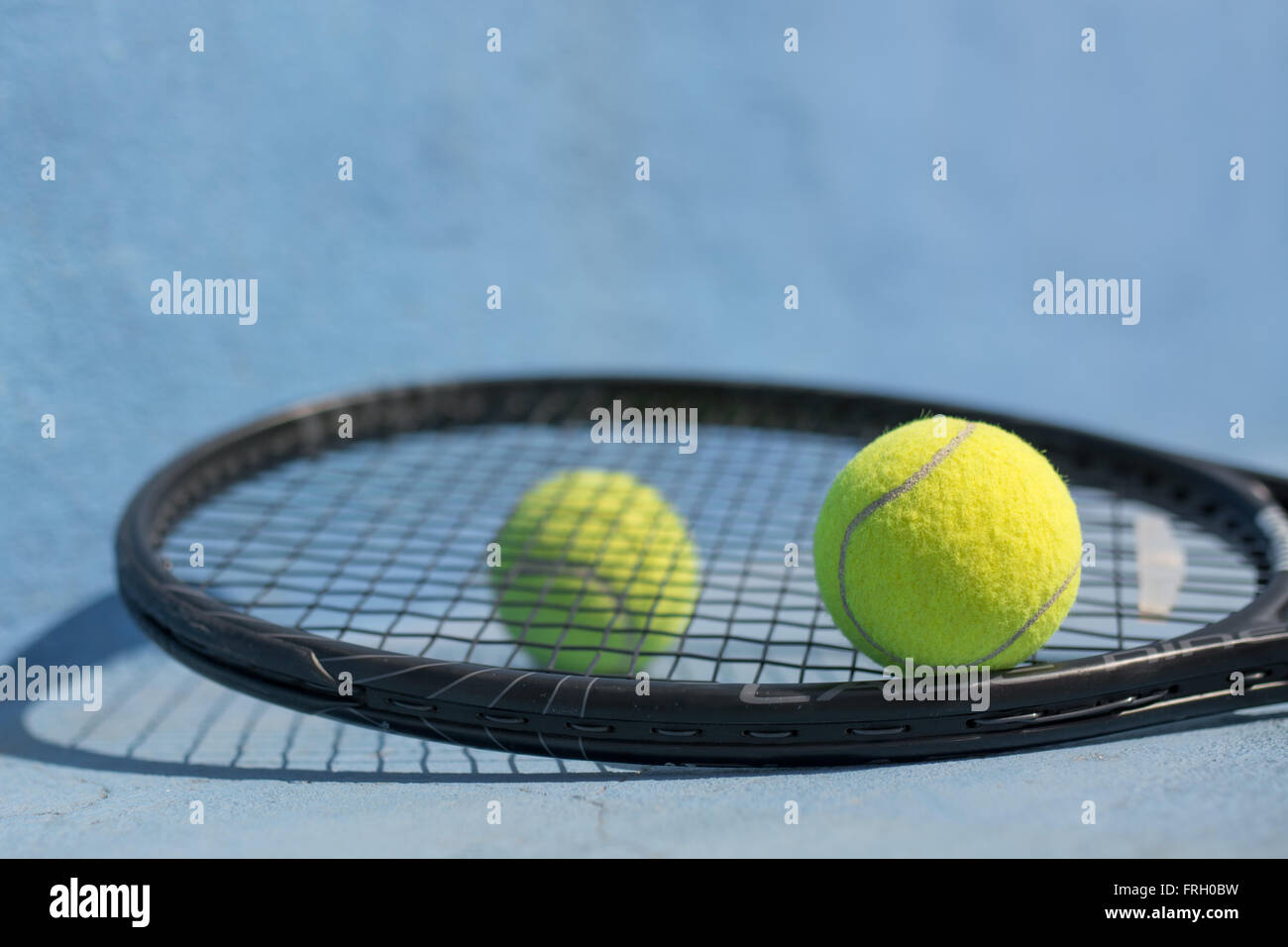 Ein Tennisball und Schläger auf blauen Tennisplatz. Stockfoto