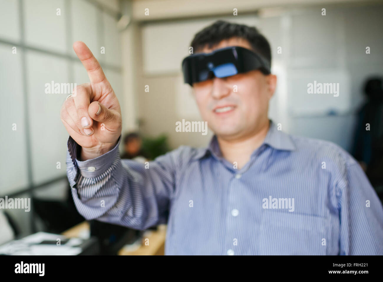 Mann in einer virtual-Reality-Helm Finger nach oben zeigt. Stockfoto
