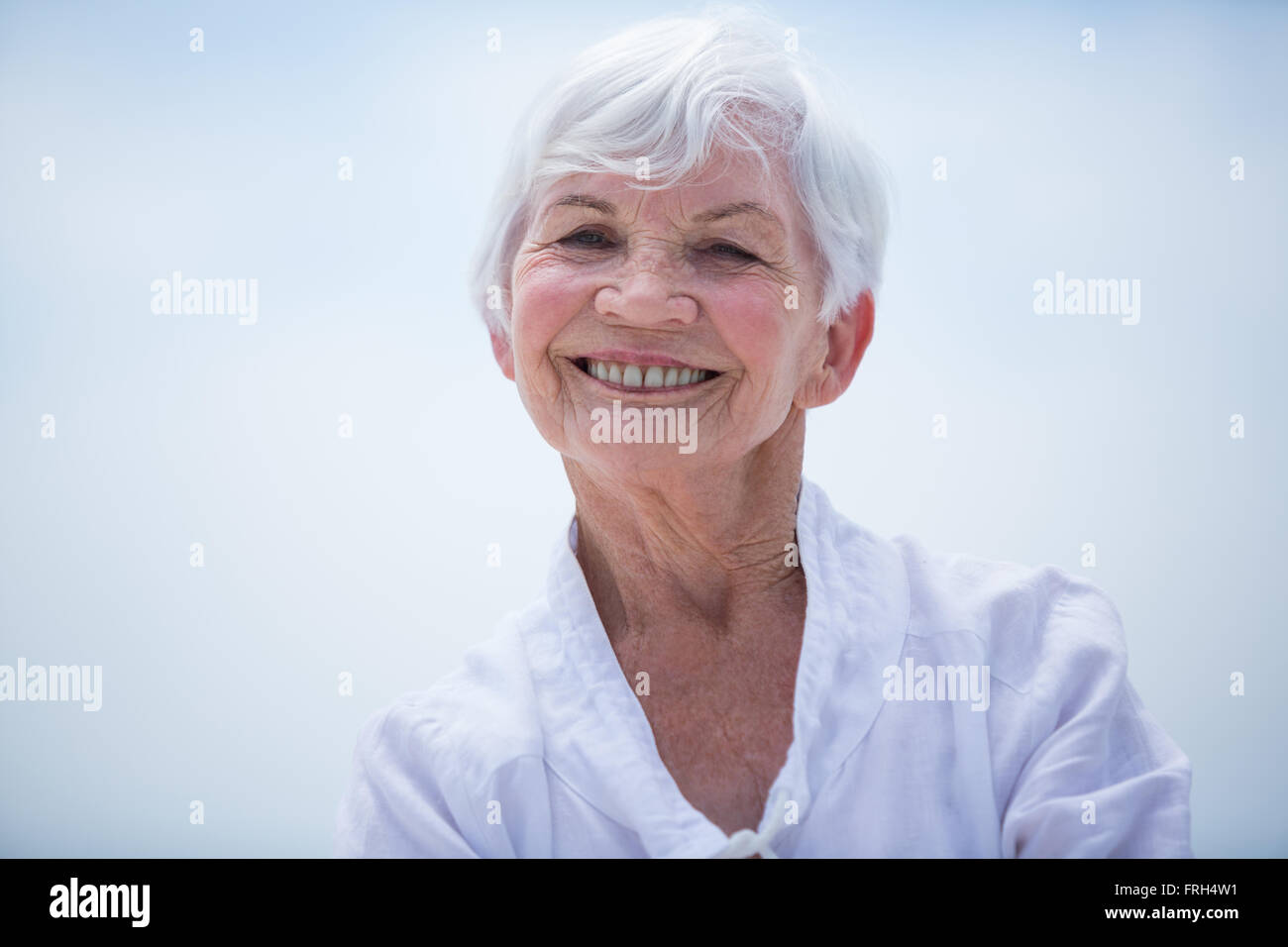 Porträt der lächelnde senior Frau gegen Himmel Stockfoto
