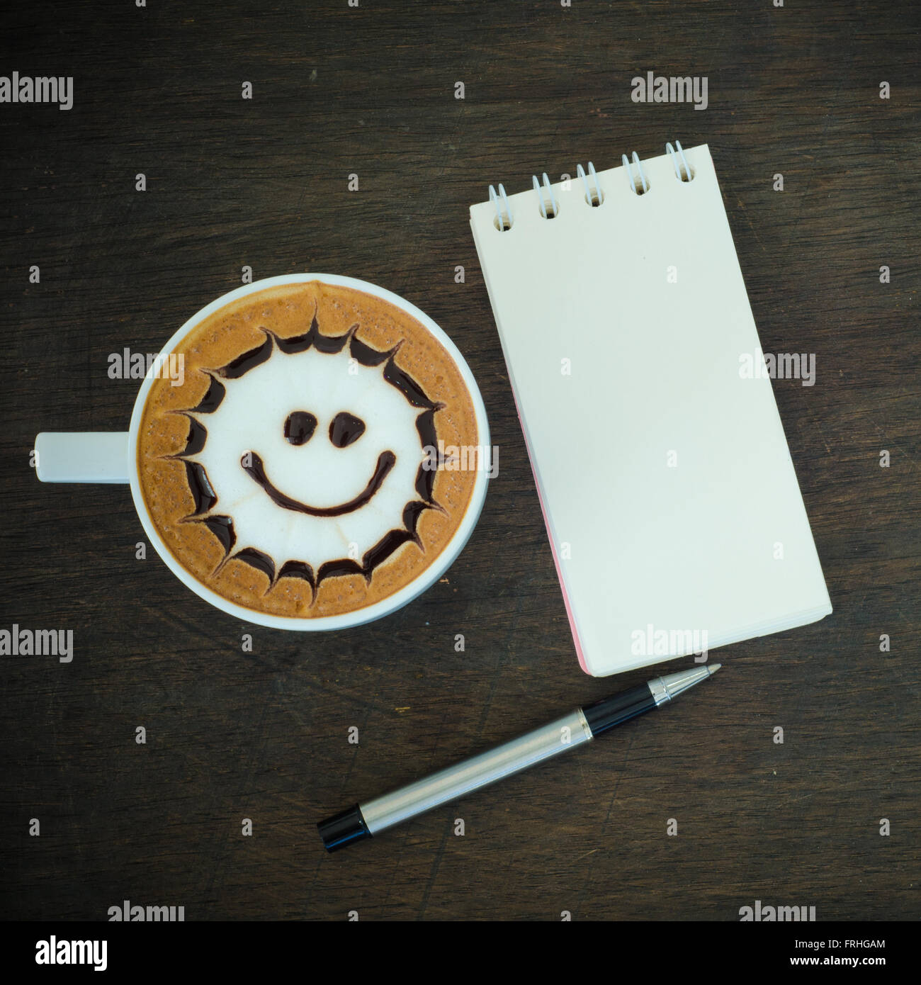 Latte Art Kaffee und Notebook auf hölzernen Hintergrund Stockfoto