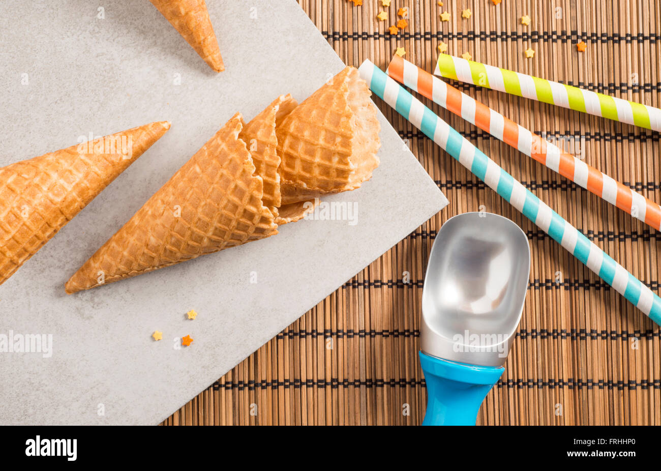 Bunte Zucker Streusel, Strohhalme und Eistüten. Vorbereitung für Party oder Feier. Konzept der Food-Styling. Stockfoto