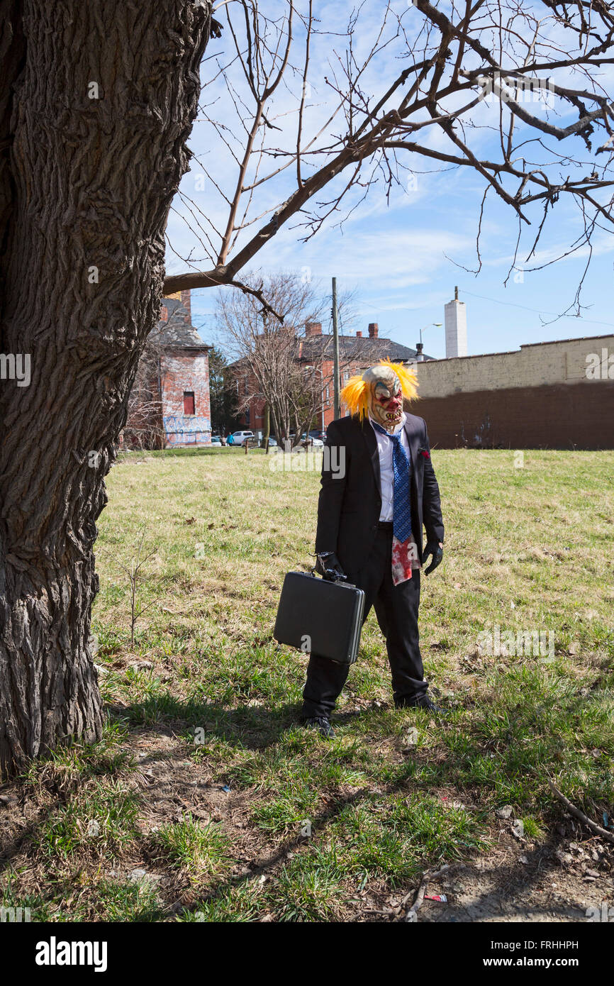 Detroit, Michigan - ein Mann, gekleidet wie ein Irrer Clown in ein unbebautes Grundstück entlang der Marche du Nain Rouge steht. Stockfoto