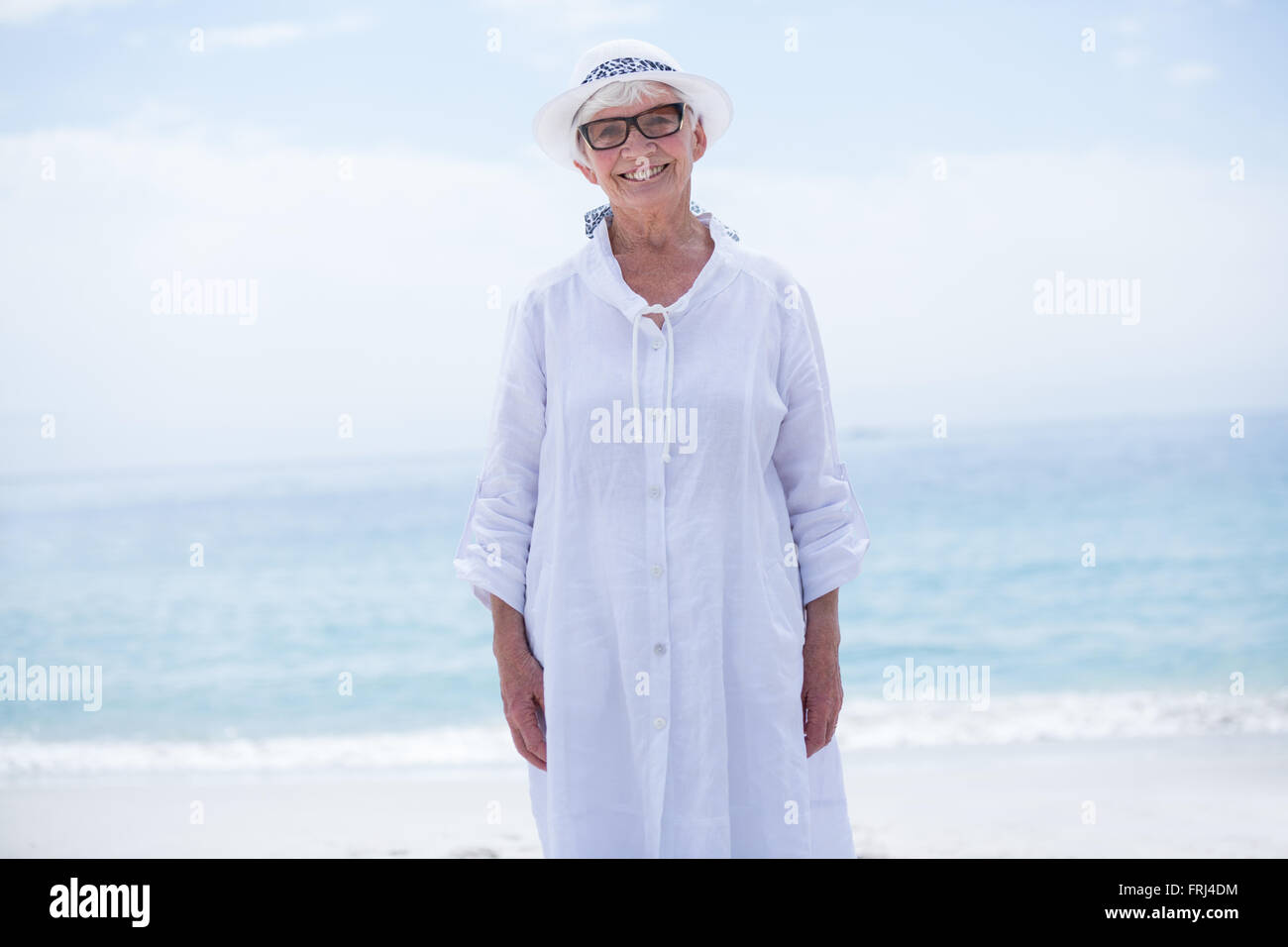 Gerne ältere Frau, die im Sea Shore Stockfoto