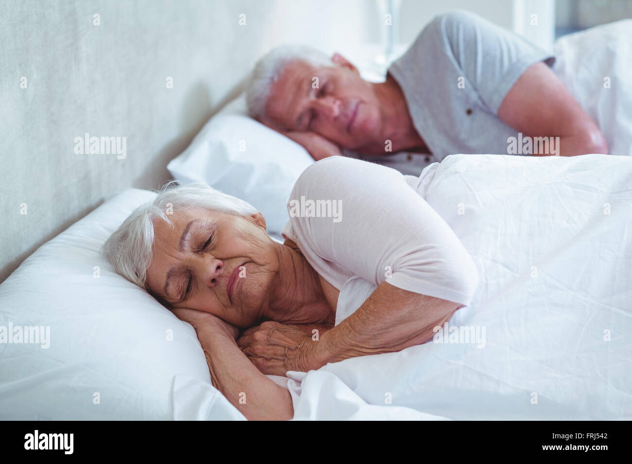 Älteres paar schläft auf Bett Stockfoto