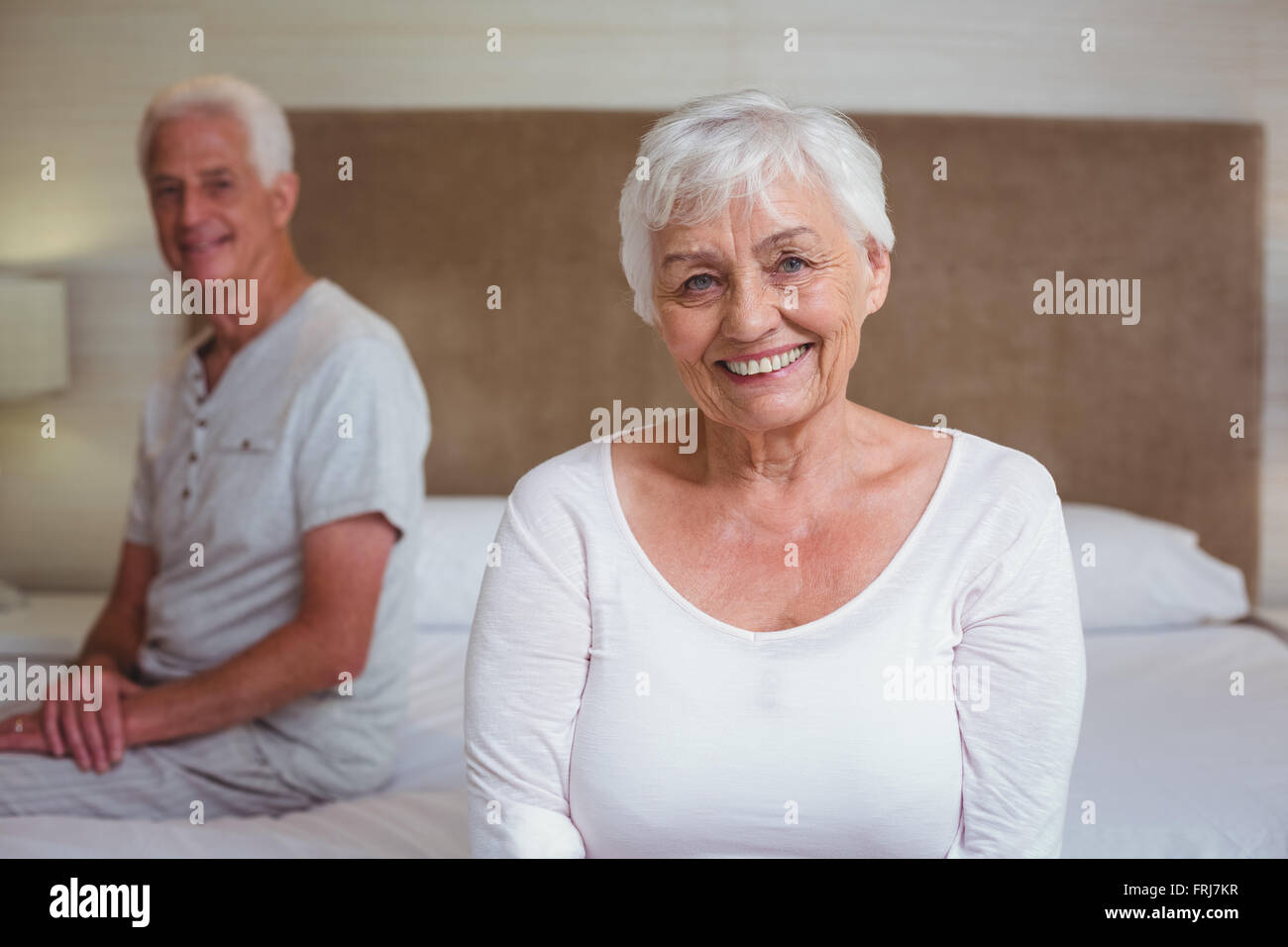 Ältere Frau mit Mann sitzt auf Bett Stockfoto