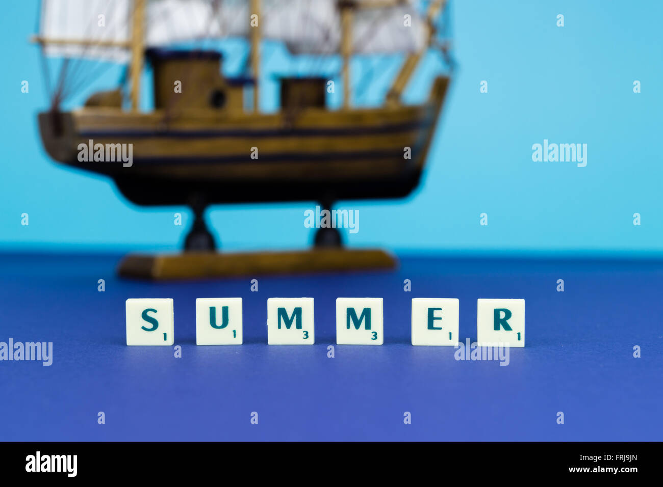 Holzschiff mit Zeichen auf blauem Hintergrund Stockfoto